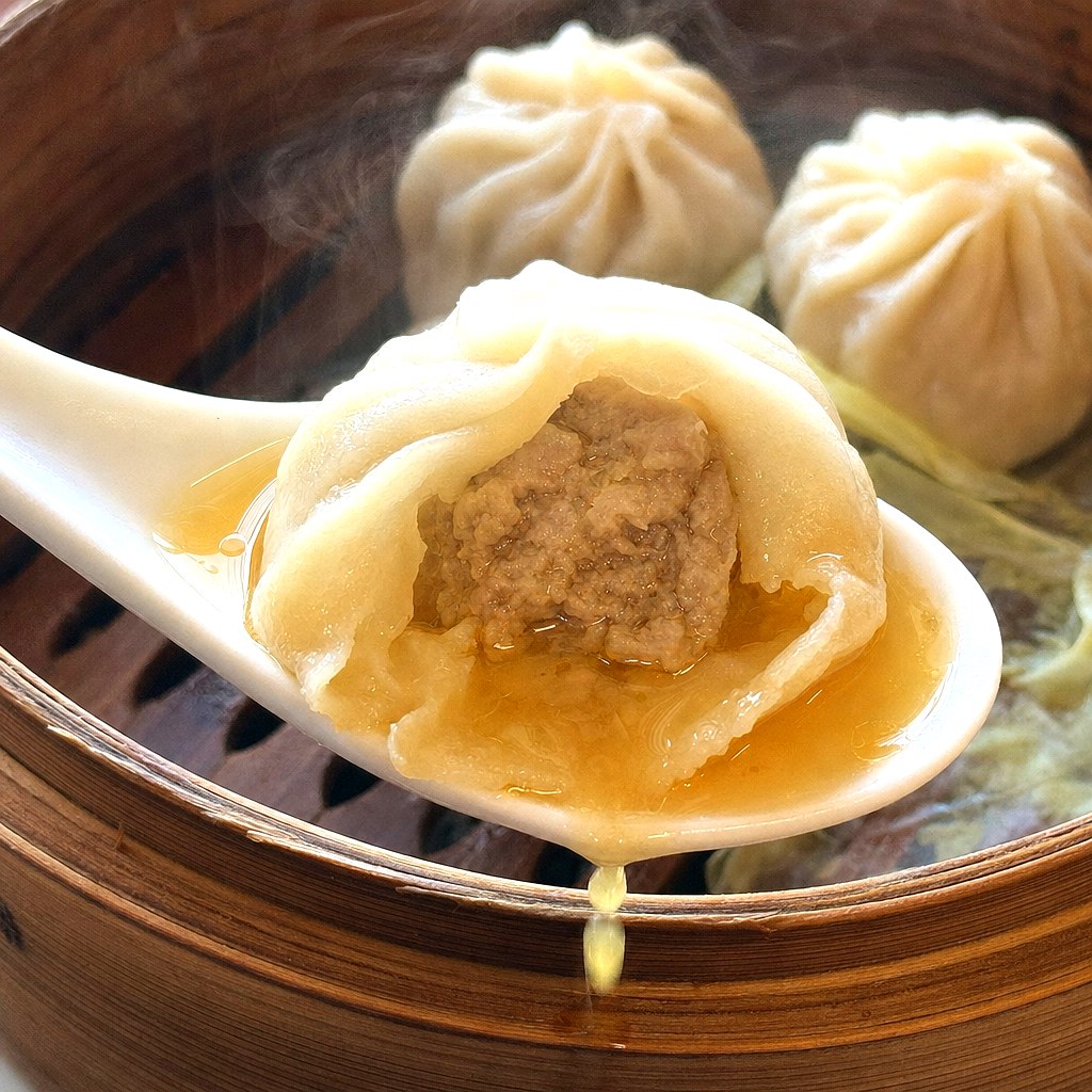 れんげの上でスープがあふれる元祖ハルピンの小籠包の断面